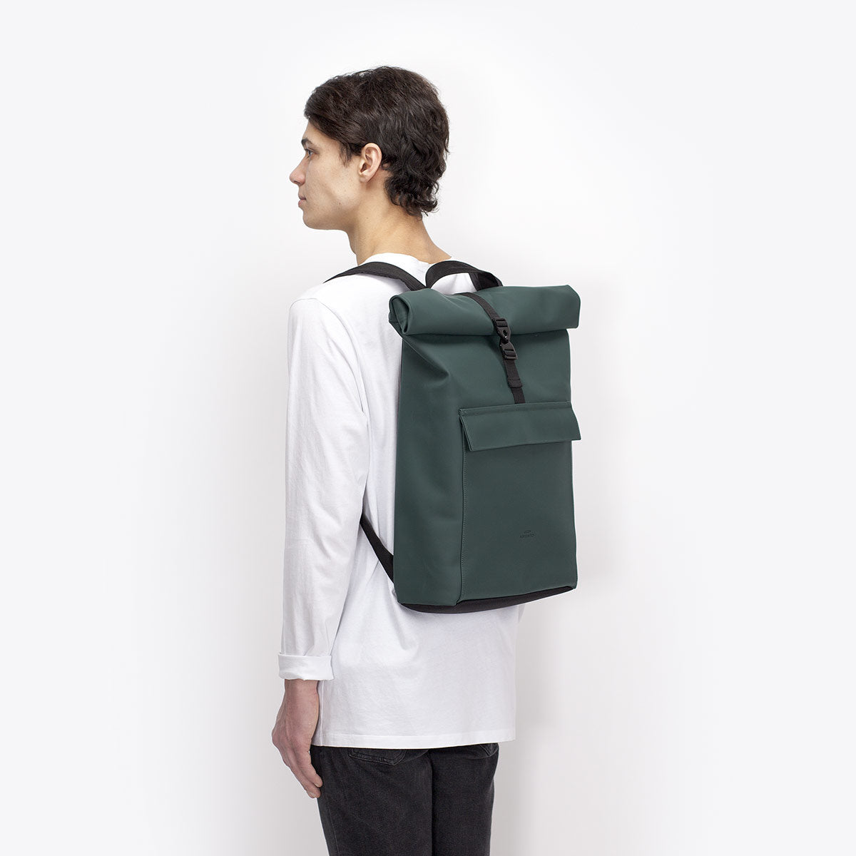 Jasper Lotus Forest Backpack shown from the side on a model wearing a white long-sleeve shirt.