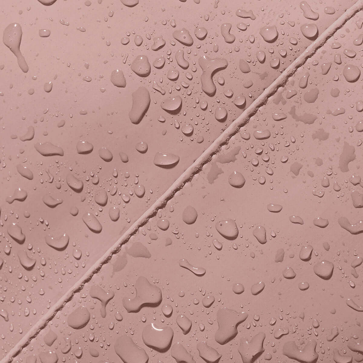 Close-up of waterproof material on Kito Mini Lotus Rose Backpack with droplets.
