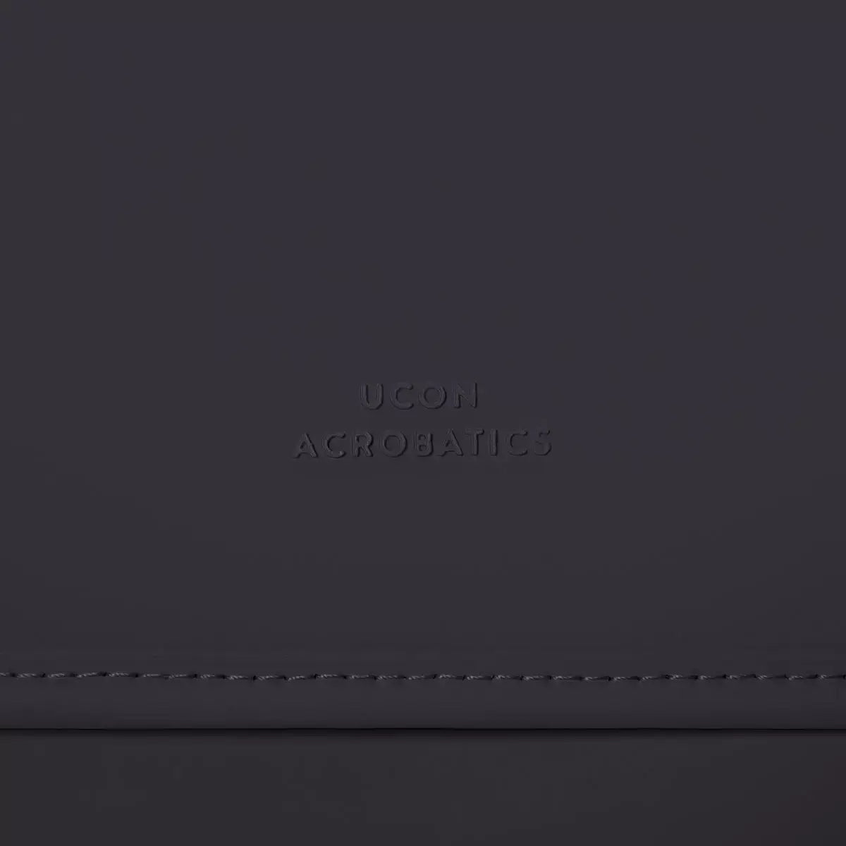 UCON Acrobatics logo embossed on a dark backpack fabric.