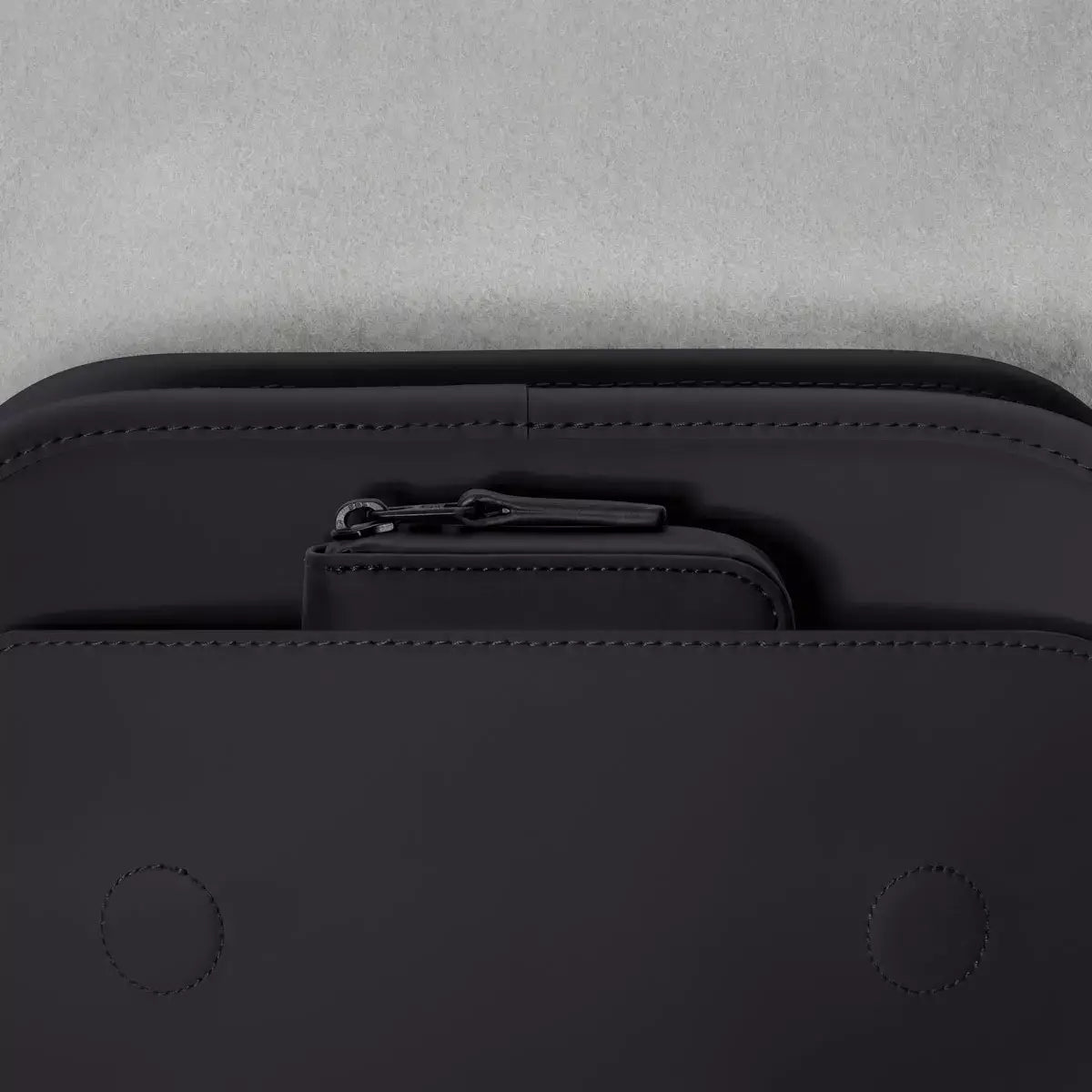 Adina Mini Lotus Infinity Black Backpack top view showing zippered pocket and sleek design.