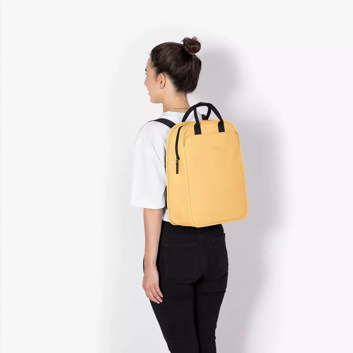 Alison Lotus Infinity Lemon Backpack worn by a model, showcasing its sleek design and vibrant lemon color.