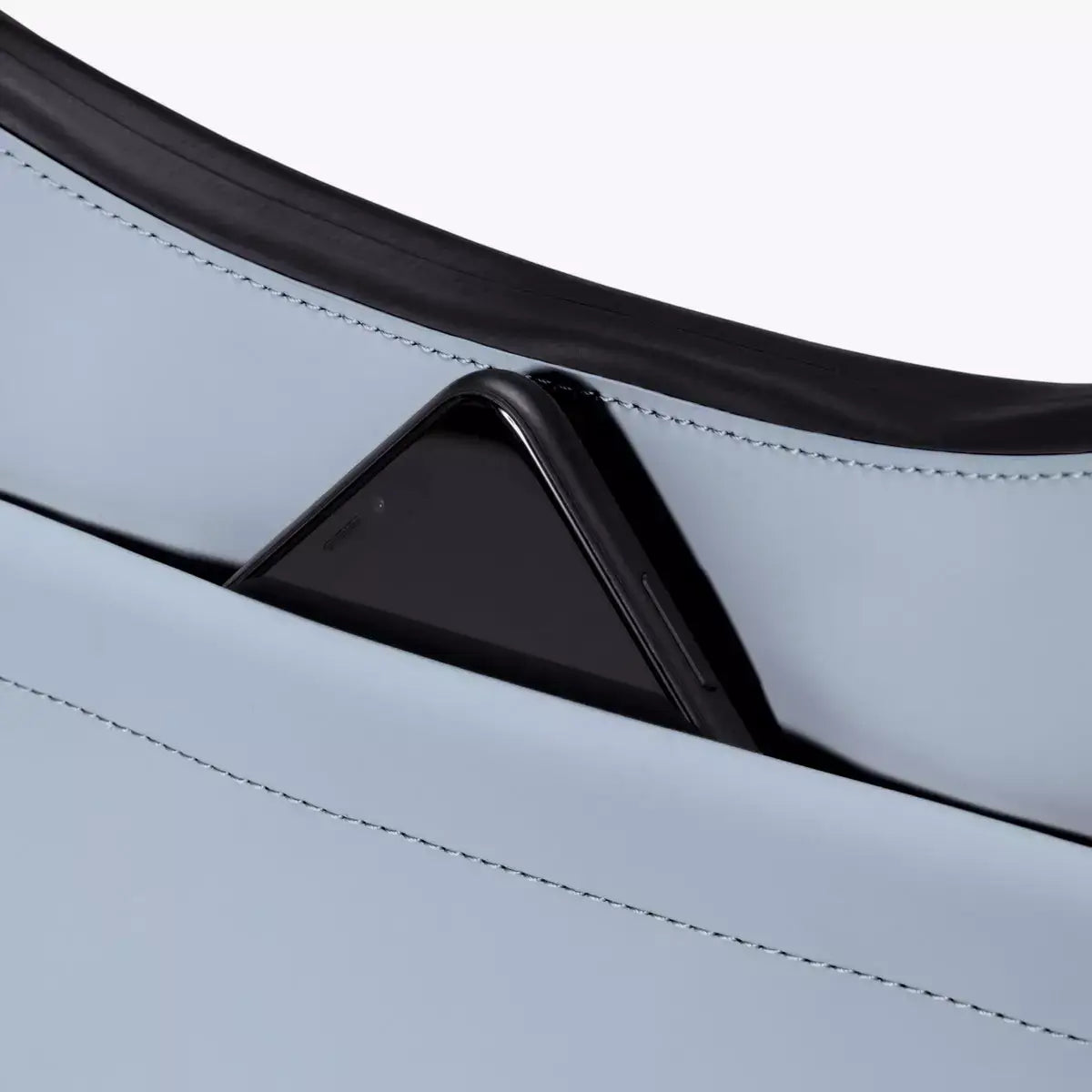 Alva Medium Lotus Infinity Fog Blue Shoulder Bag showing a smartphone in the front pocket.