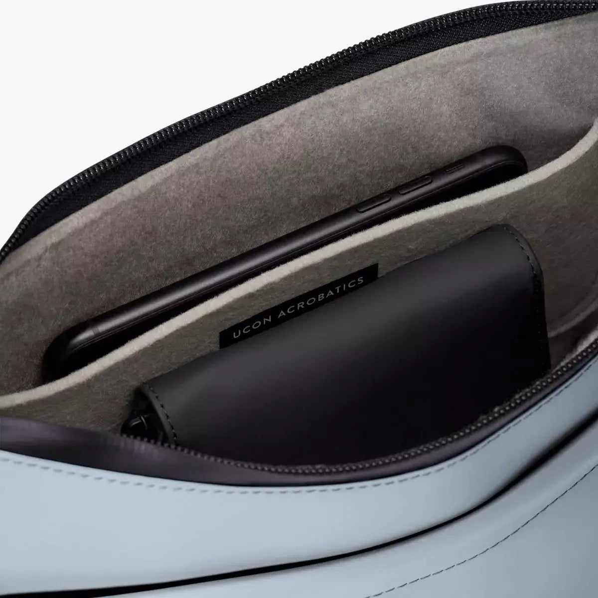 Interior view of Alva Medium Lotus Infinity Fog Blue Shoulder Bag showing soft felt and pockets for phone and accessories.