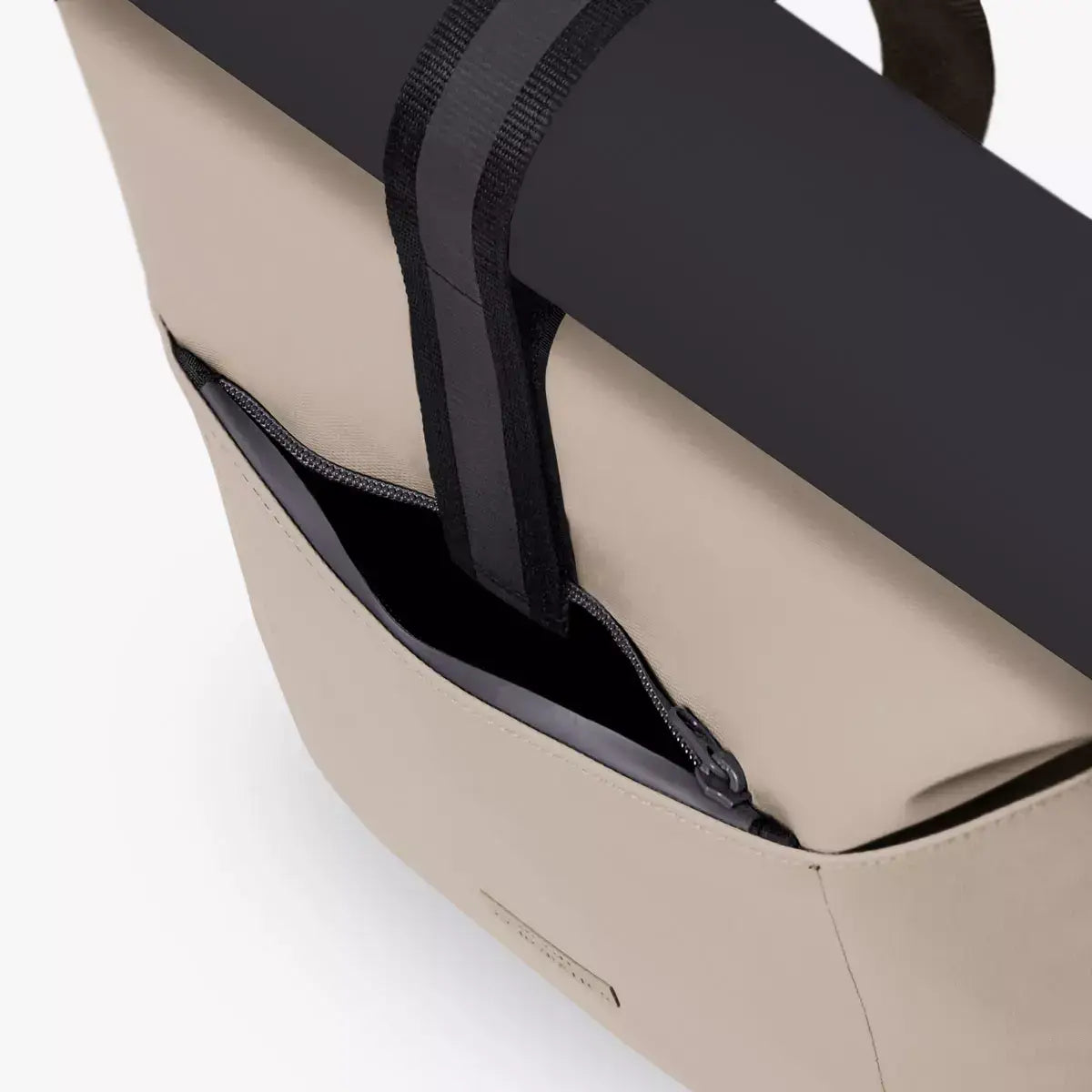 Hajo Aloe Sand Black Backpack showing roll-top closure and extra side zipper features.