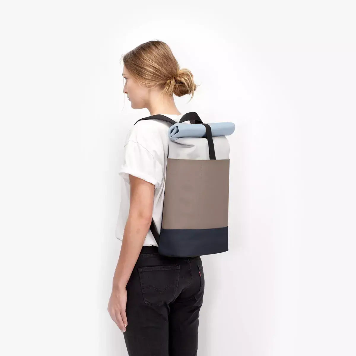 Hajo Lotus Infinity Glacier Grey Dark Sand Backpack shown on a model, showcasing its stylish and functional design.