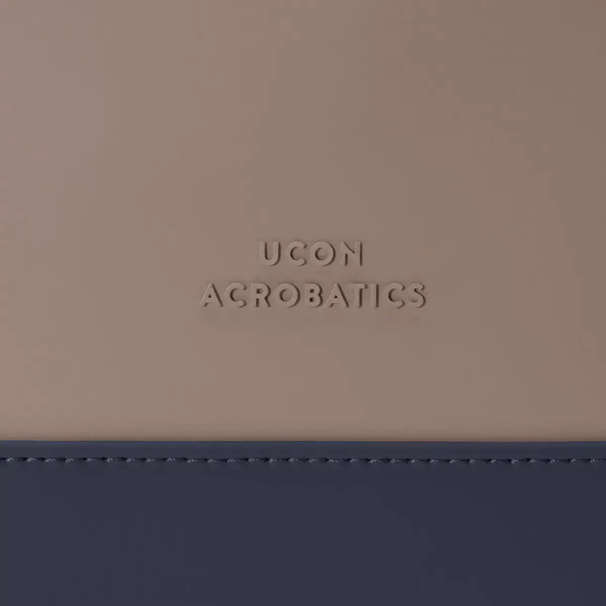 UCON Acrobatics logo detail on a stylish backpack in neutral tones.