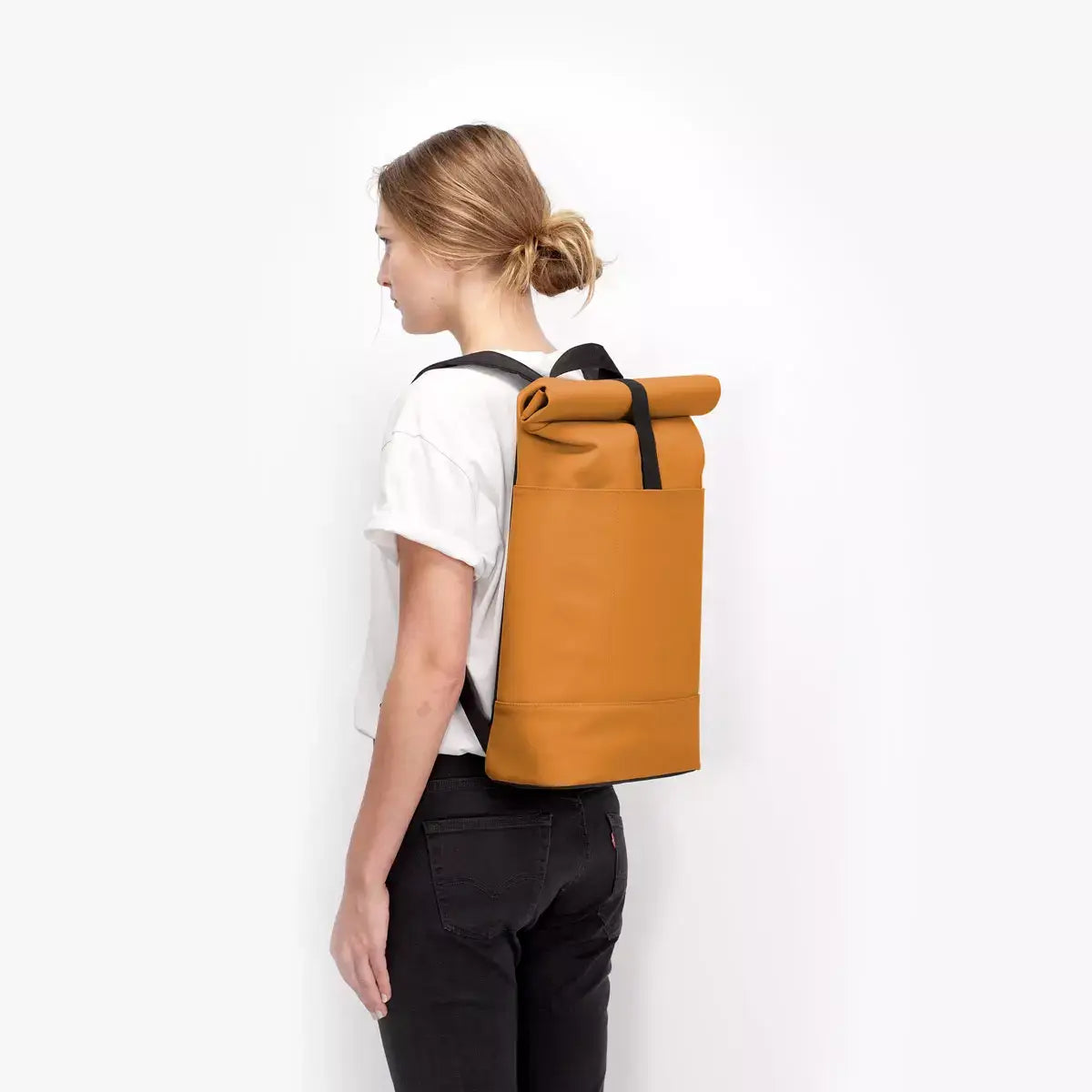 Hajo Lotus Infinity Honey Mustard Backpack in use, showcasing its stylish roll-top design and durable material.