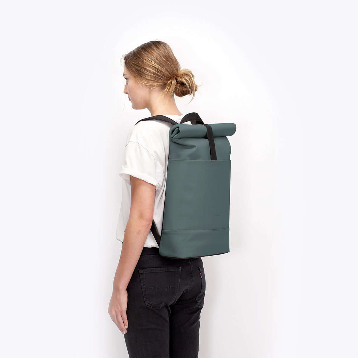 Hajo Lotus Pine Green Backpack showcased on a model, featuring a roll-top design and padded straps.
