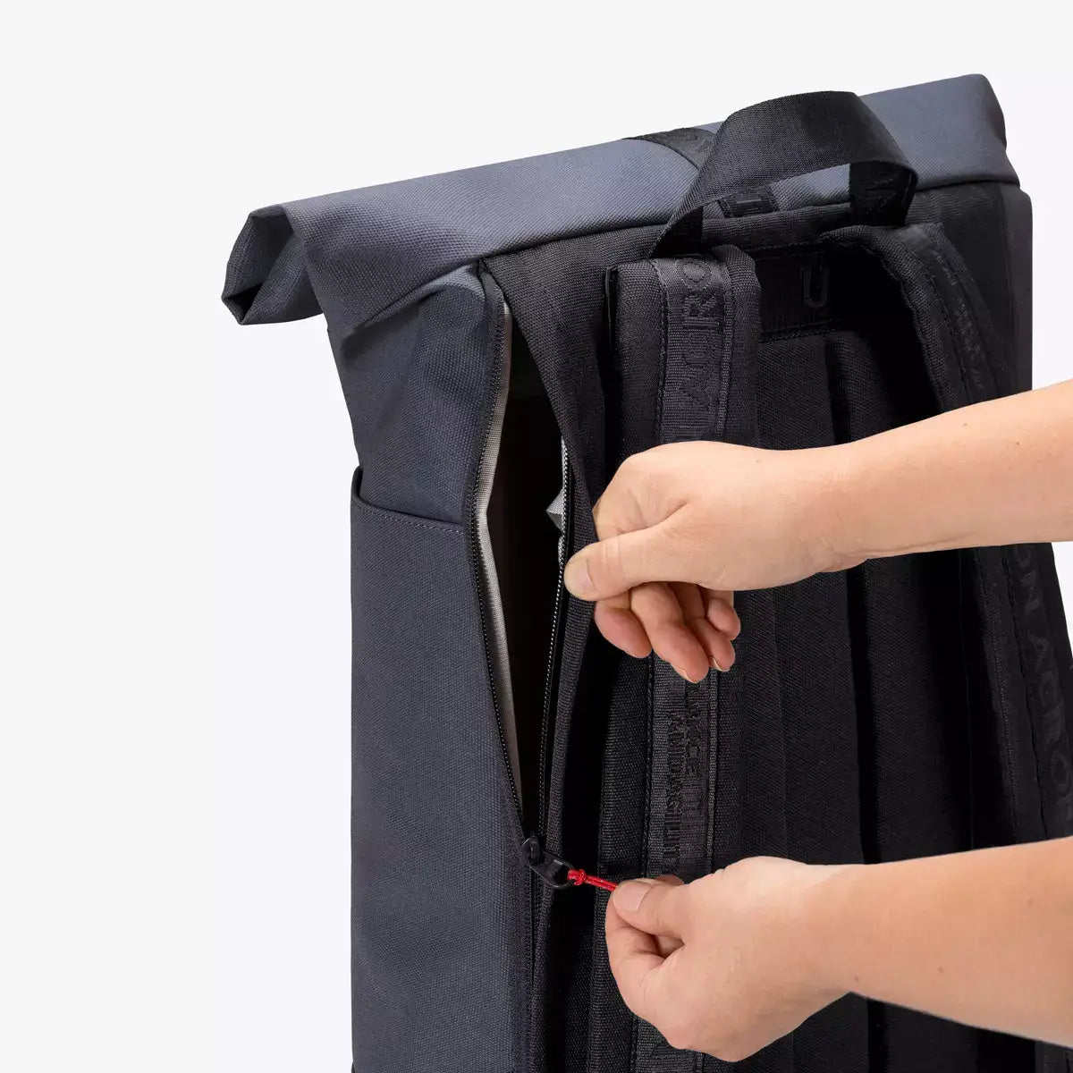 Hands unzipping the side pocket of the Hajo Phantom Ocean Blue Reflective Backpack.