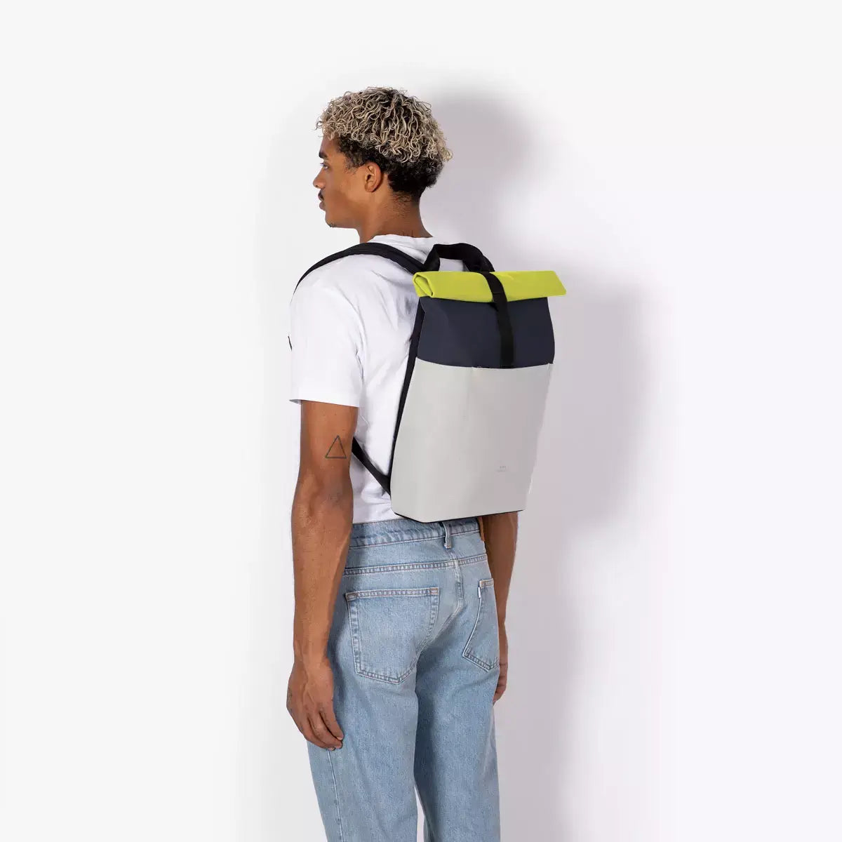 Hajo Mini Lotus Dark Navy Light Grey Backpack showcased on a model, featuring a roll-top closure and padded straps.