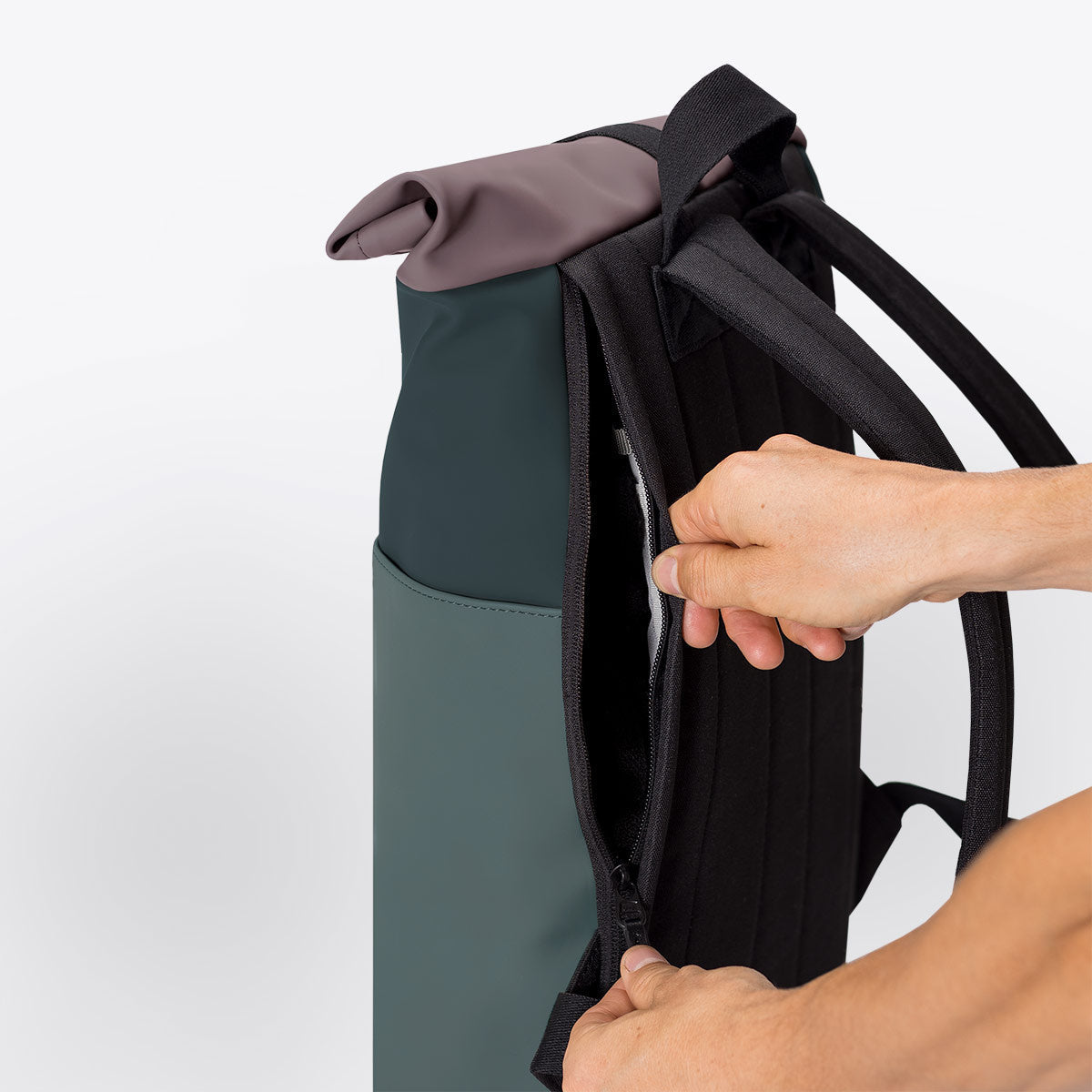 Hajo Mini Lotus Forest Pine Green Backpack showing roll-top closure and side zipper with padded straps.