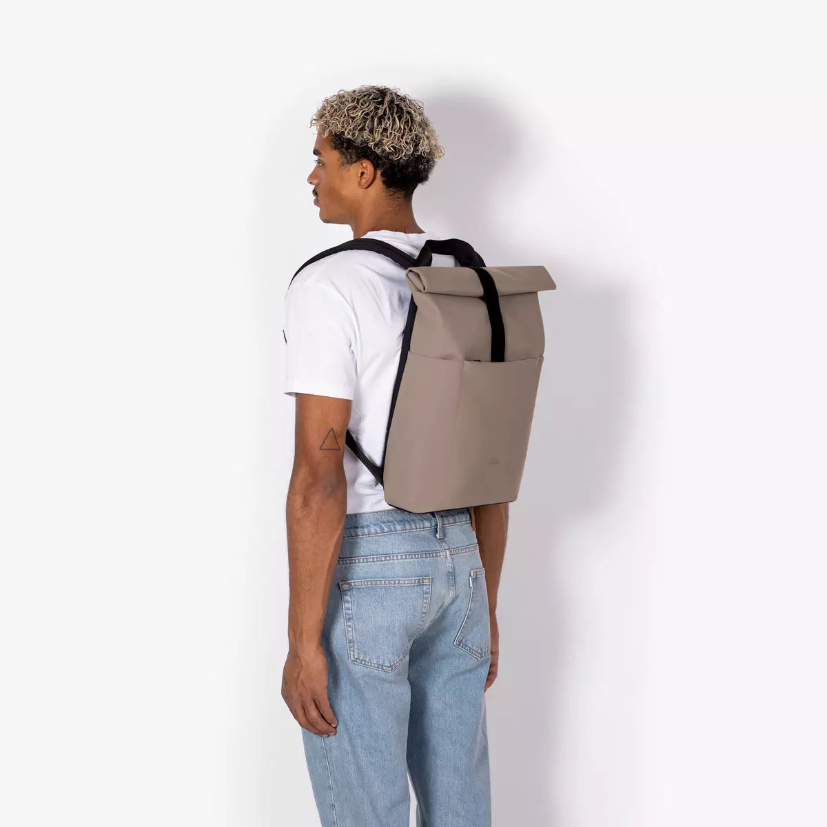 Hajo Mini Lotus Infinity Dark Sand Backpack worn by a person, showcasing its stylish design and durable features.