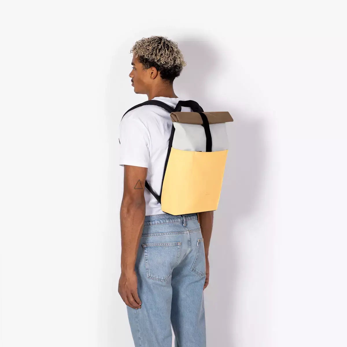 Hajo Mini Lotus Infinity Glacier Grey Lemon Backpack shown on a model, showcasing its sleek design and vibrant colors.
