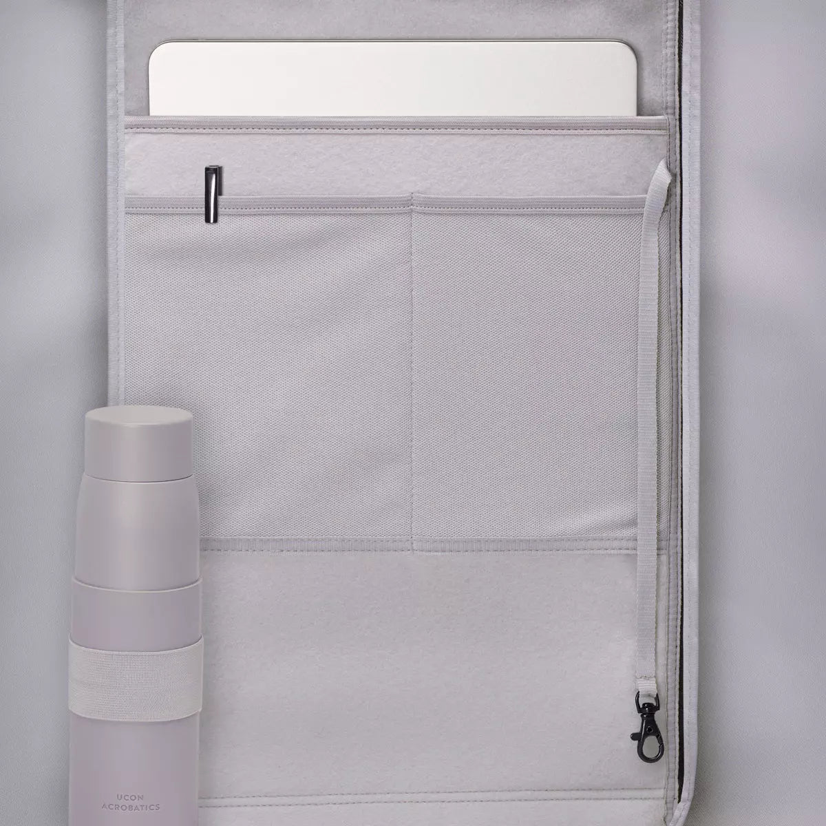 Interior of Hajo Mini Lotus Infinity Sand Backpack showing laptop compartment and pocket with a water bottle.