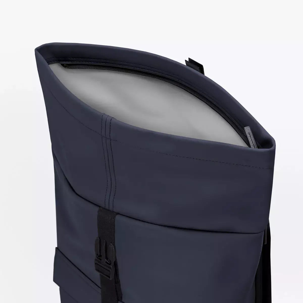 Close-up view of the Jannik Medium Lotus Infinity Dark Navy Backpack showing the waterproof roll-top design.