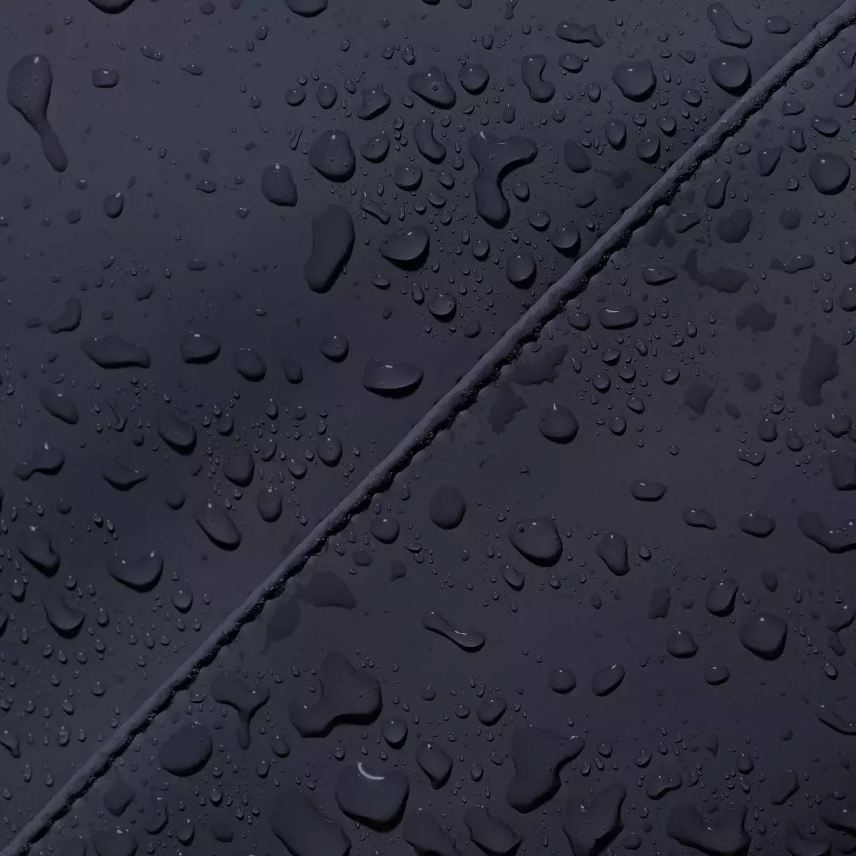 Close-up of waterproof material on Jannik Medium Lotus Infinity Dark Navy Backpack, showcasing water droplets.
