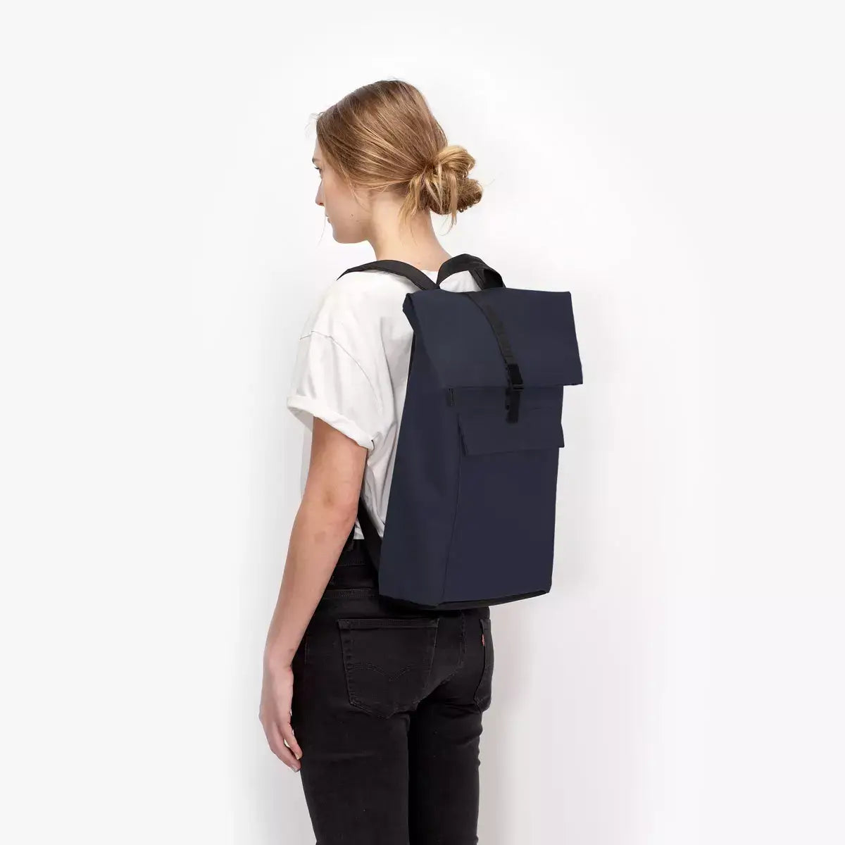Jannik Medium Lotus Infinity Dark Navy Backpack worn on the back of a model, showcasing its sleek design.