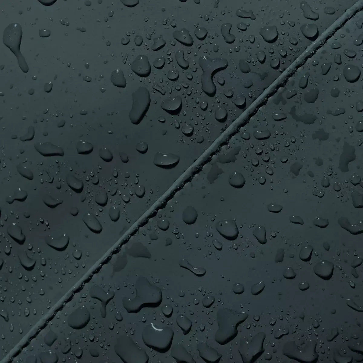 Close-up of water droplets on the waterproof material of the Jannik Medium Lotus Infinity Forest Backpack.