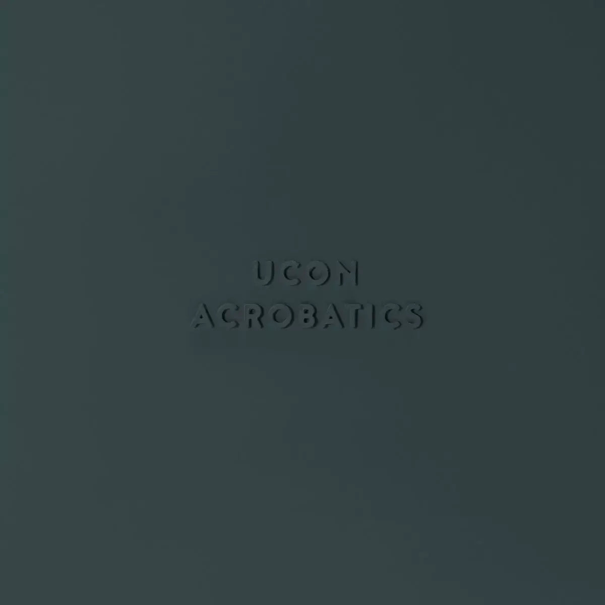 Image of Ucon Acrobatics logo embossed on a dark background.