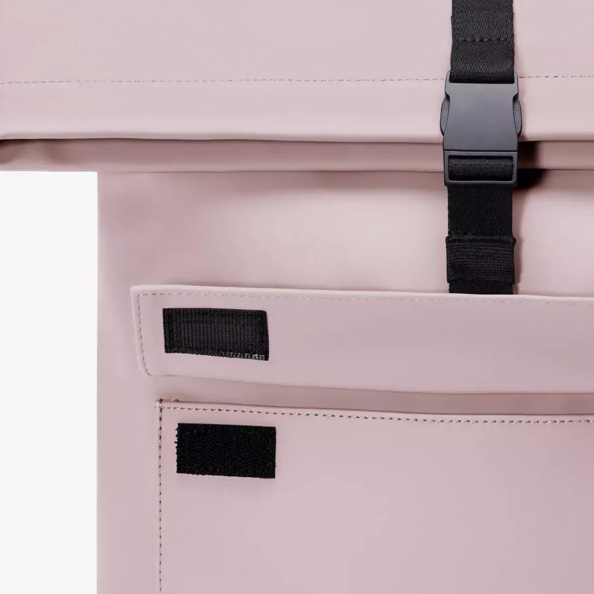 Close-up of the Jannik Mini Lotus Infinity Light Rose Backpack showing roll-top closure and side zipper.