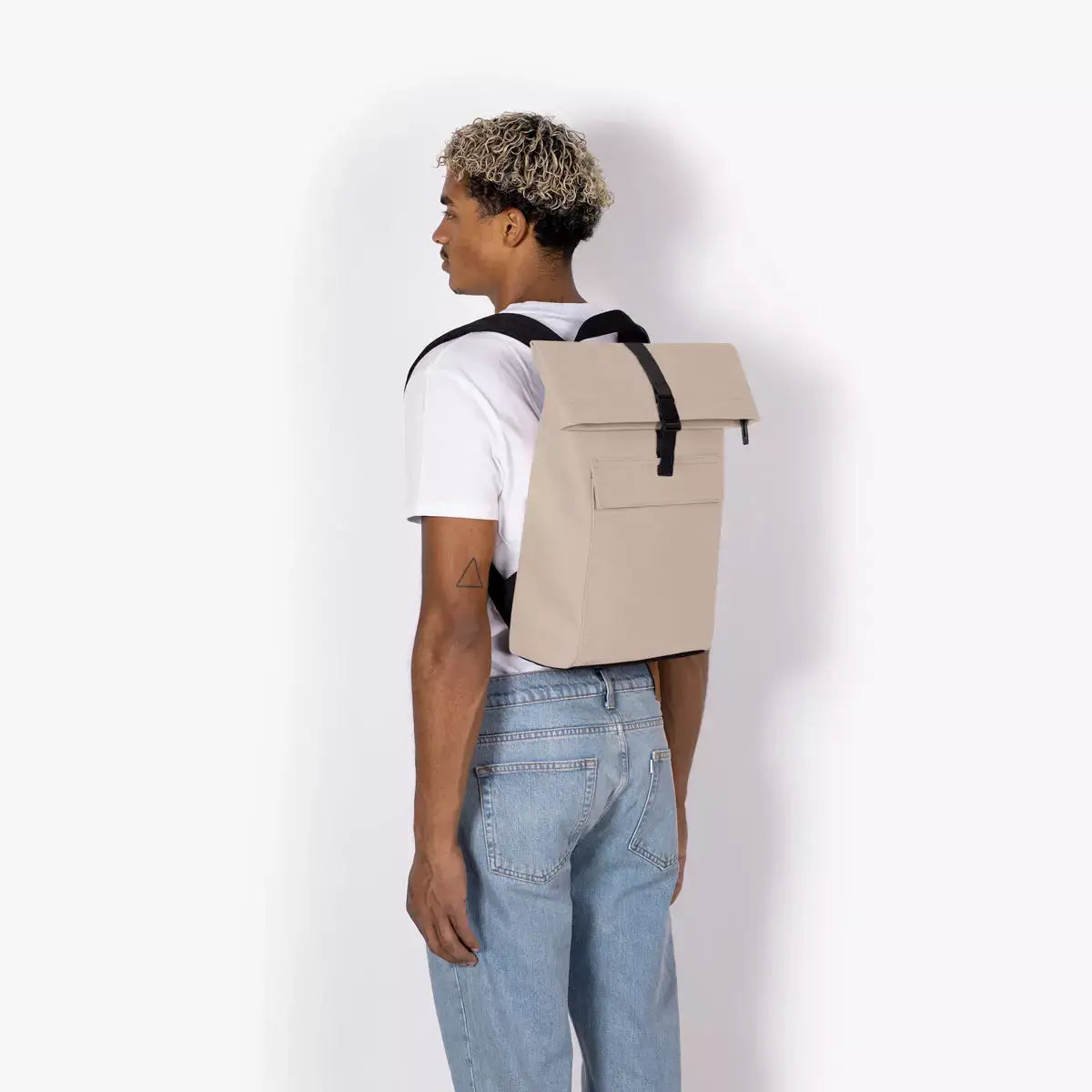 Jannik Mini Lotus Infinity Sand Backpack worn by a model from the back, showcasing its sleek design and durability.