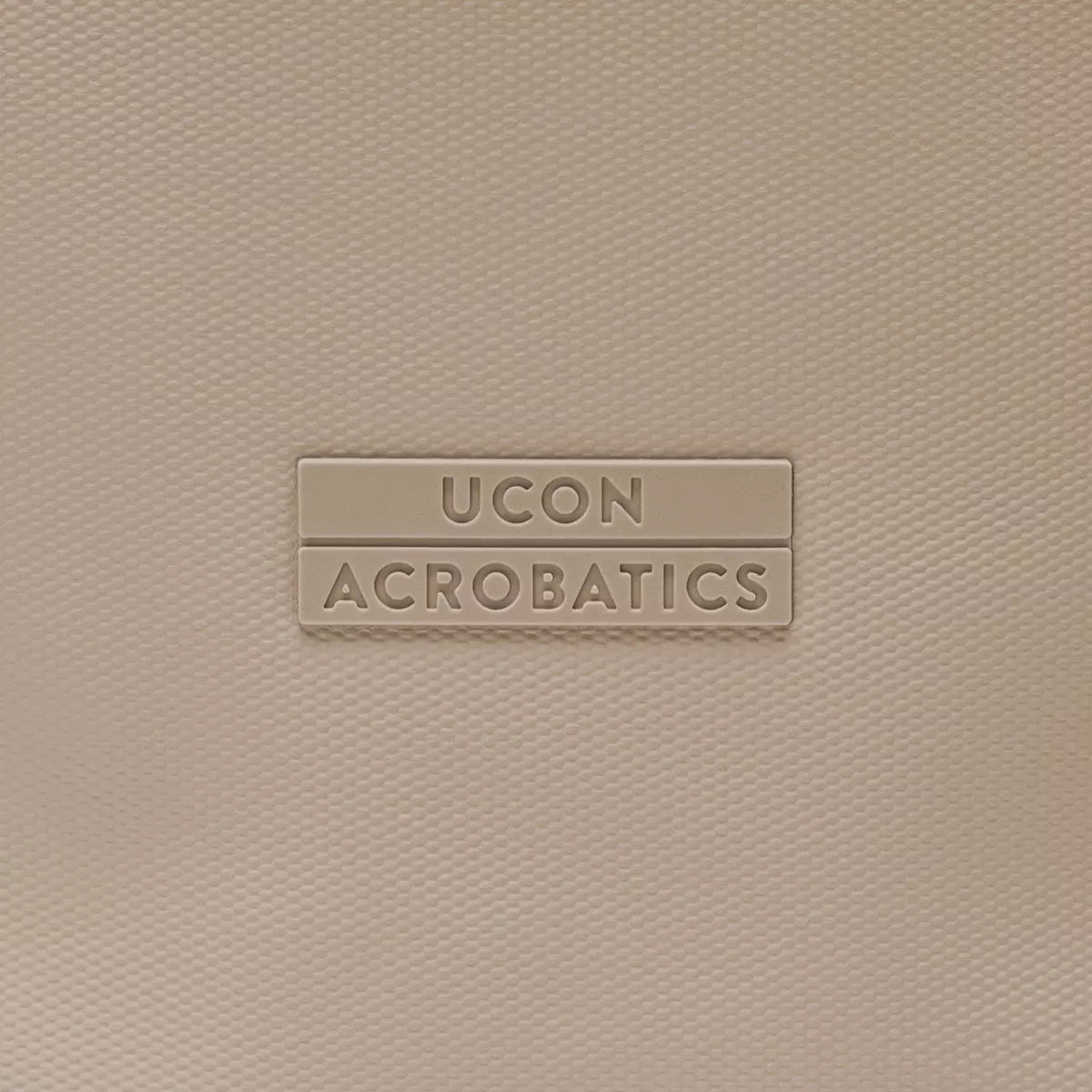 UCON ACROBATICS logo on a textured beige background.