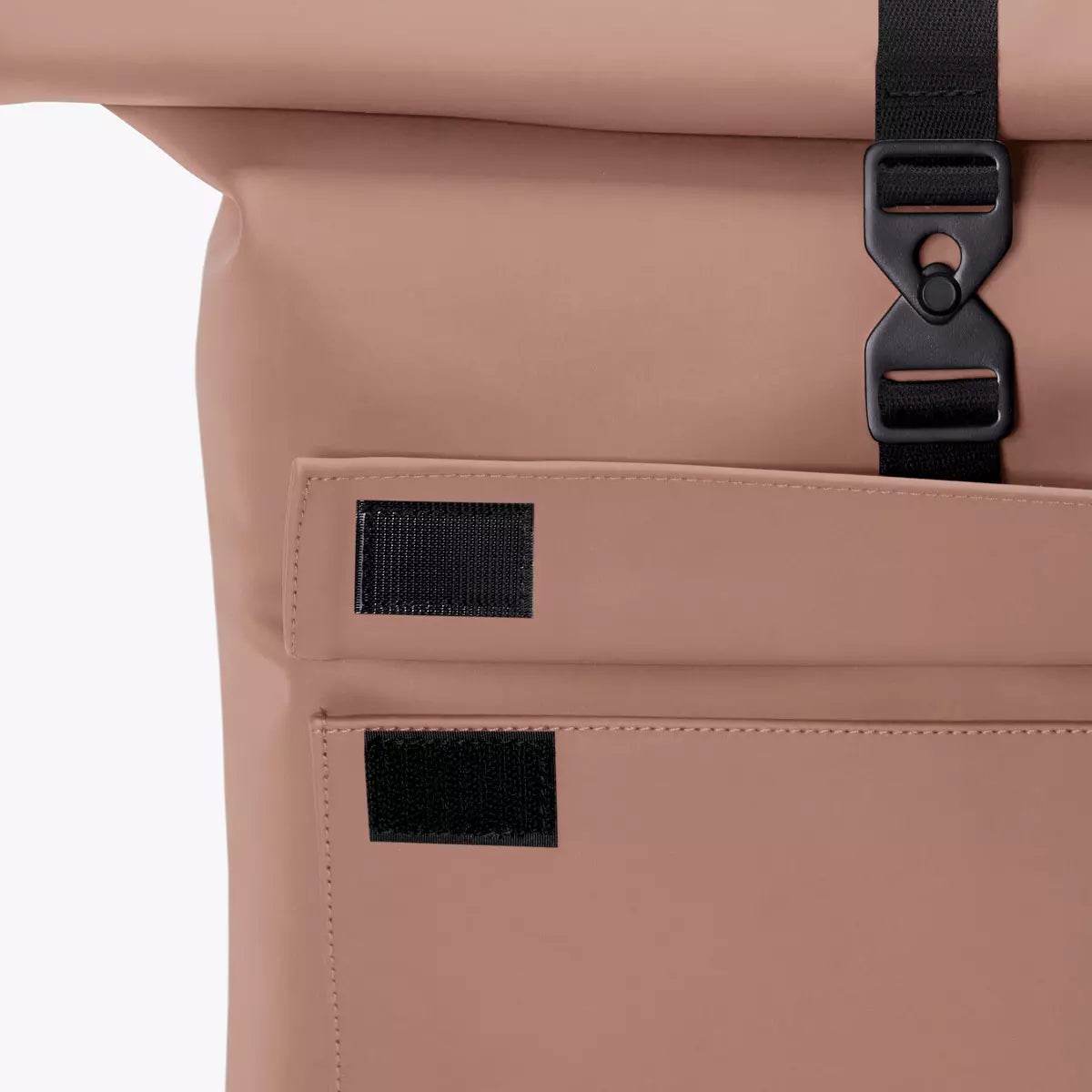 Close-up of Jasper Lotus Redwood Backpack showing roll-top and metal clip detail.