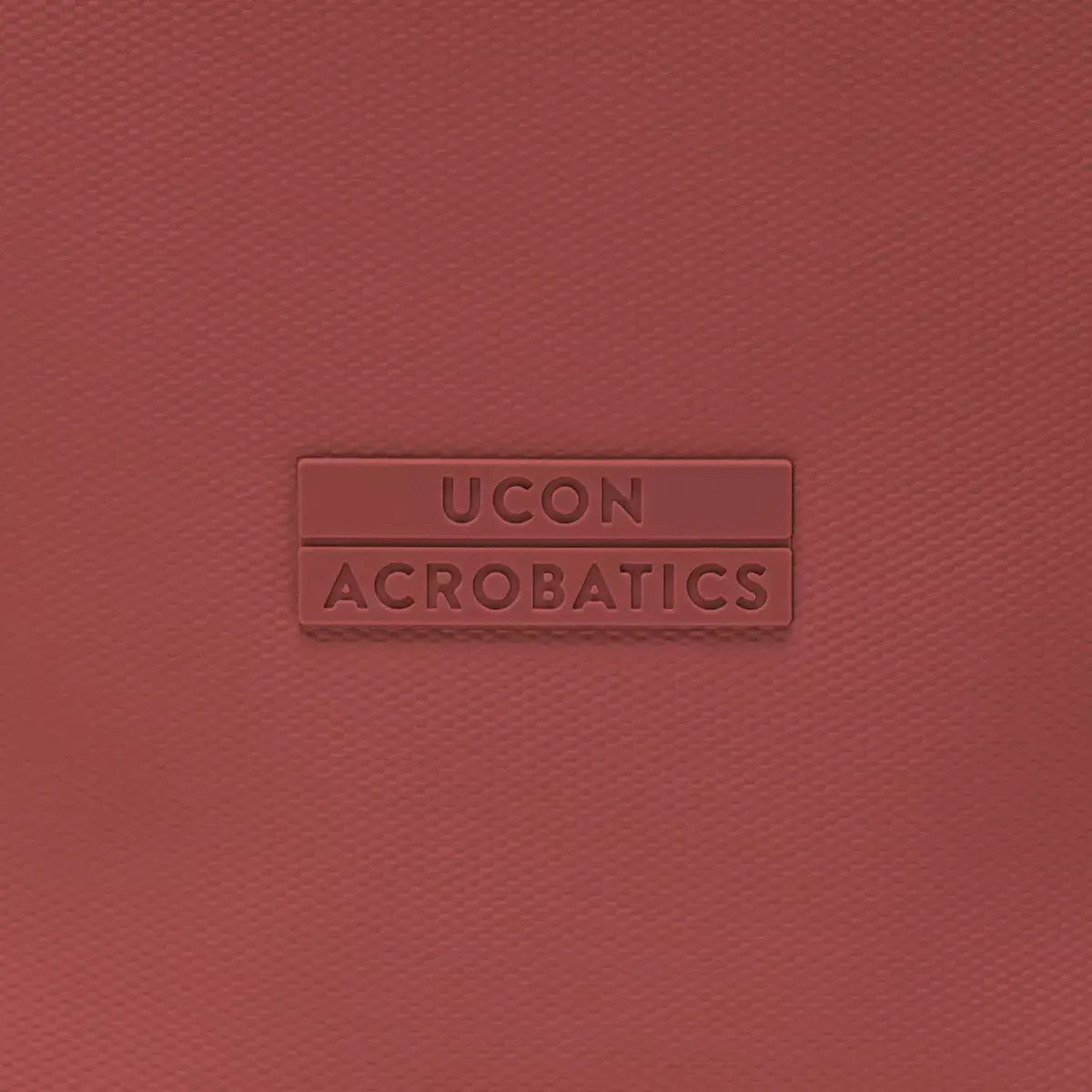 UCON Acrobatics brand logo on a red backpack background