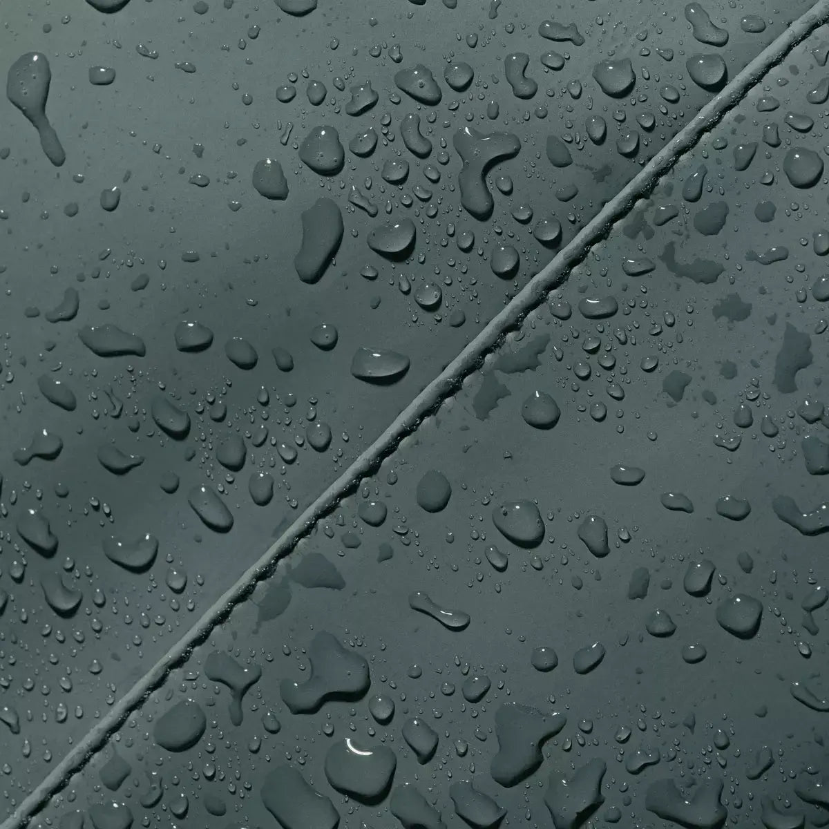 Close-up of waterproof material with droplets, showcasing durability of Jona Lotus Infinity Pine Green Bum Bag.