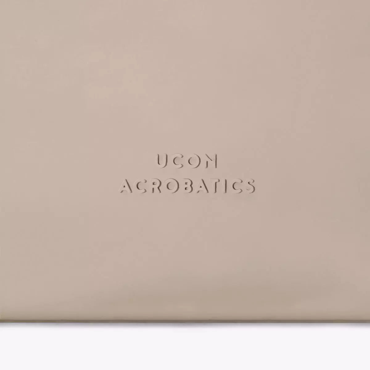 UCON ACROBATICS logo embossed on a beige bag