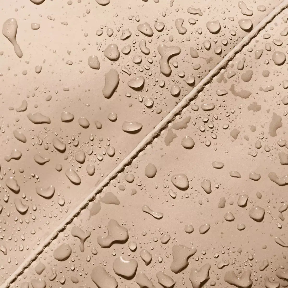 Waterproof material of the Masao Lotus Light Almond Backpack with droplets.