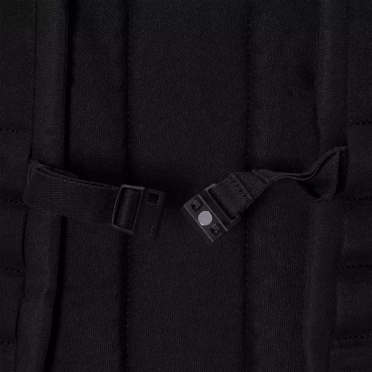 Yuto Medium Lotus Infinity Black Backpack straps and magnetic chest strap detail.