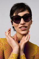 Model wearing Louise Dark Tortoise Sunglasses with a confident smile and stylish outfit.