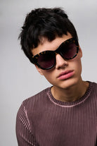 Louise Dark Tortoise Sunglasses worn by a model, featuring a cat eye design for UV protection and eco-friendly materials.