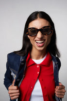 Woman smiling while wearing Luna Havana Sunglasses, featuring a bio nylon frame and polycarbonate lenses.