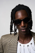 Model wearing Luna Havana Sunglasses with a stylish outfit and expressive look, showcasing modern eyewear fashion.