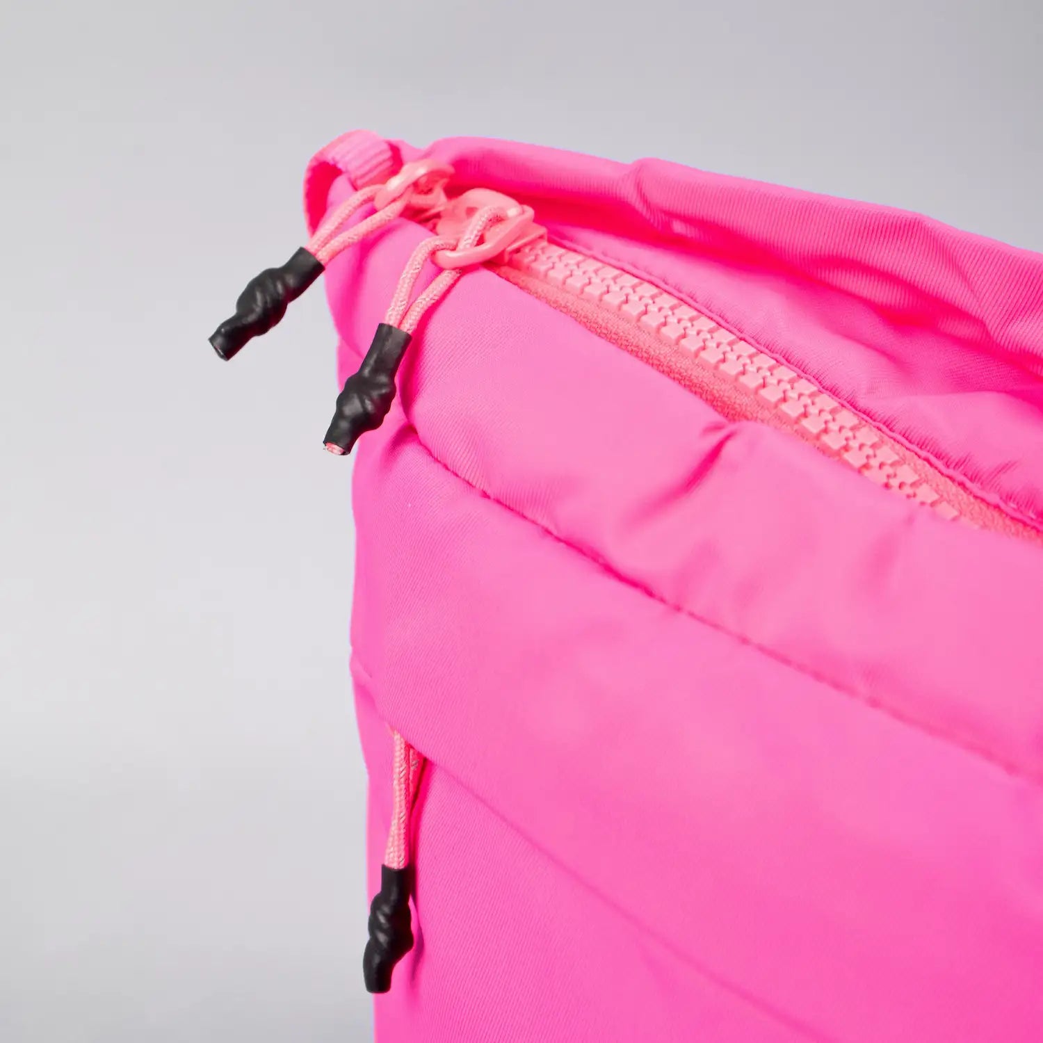 Close-up view of the zipper detail on a pink bag highlighting its durable design.