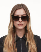 02 Core Brown Sunglasses worn by a model, showcasing unisex design and high-quality anti-scratch lenses.