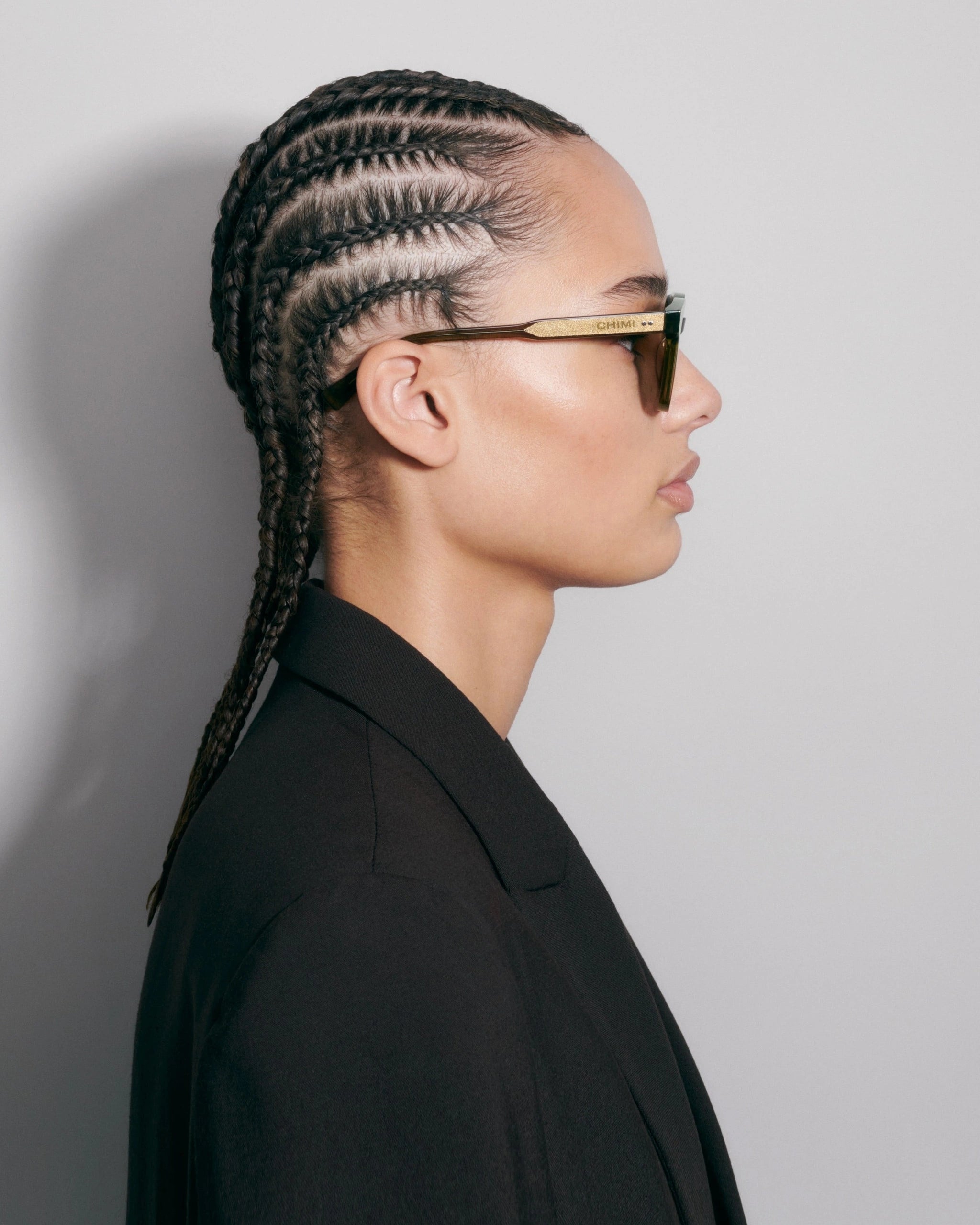 02 Core Green Sunglasses worn by a model with braided hair, showcasing stylish design and perfect fit.