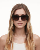 Model wearing 04 Core Black Sunglasses showcasing stylish design and perfect fit for various face shapes.