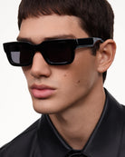 05 Core Black Sunglasses worn by a model, showcasing stylish design and 100% UVA + UVB protection.