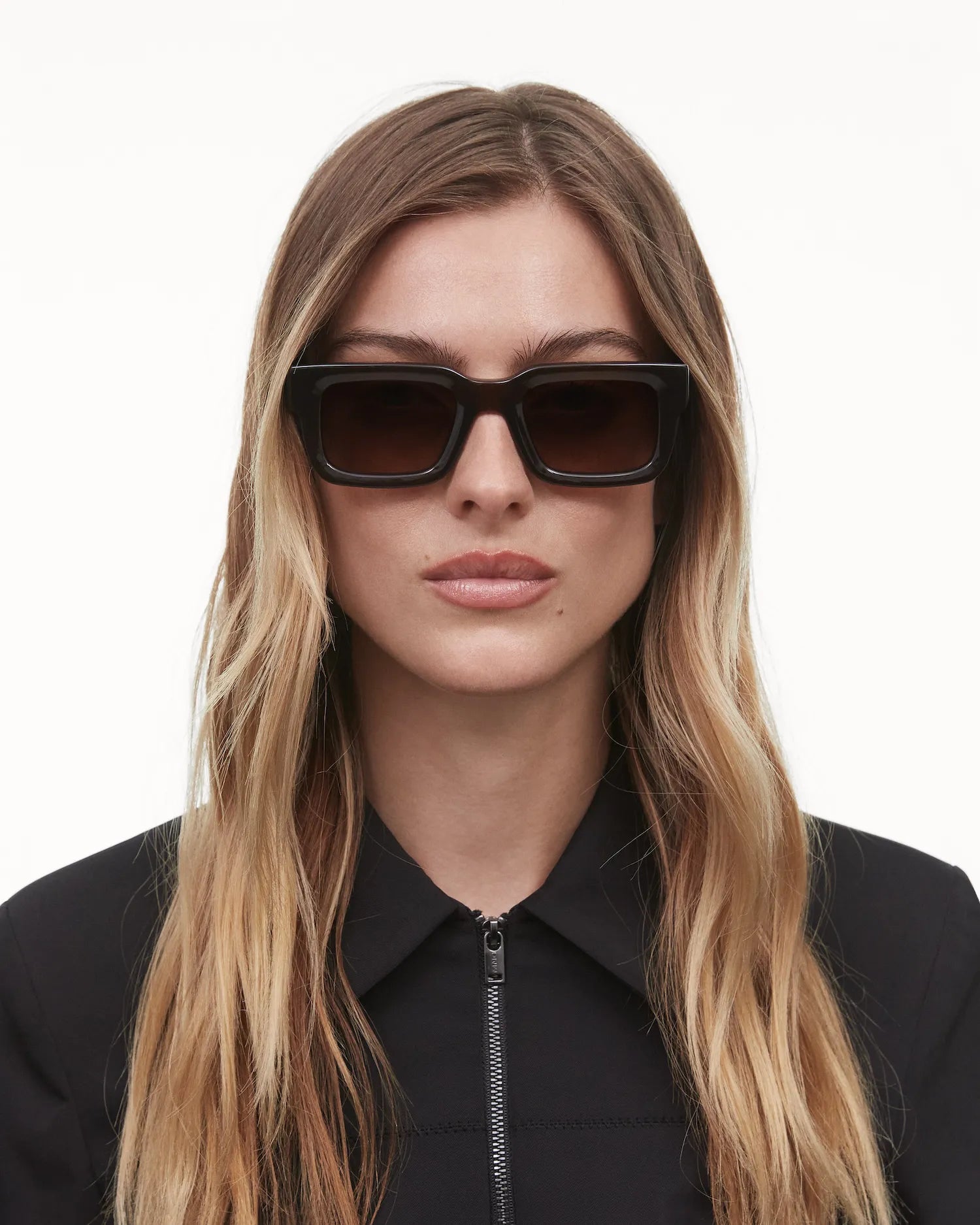 Model wearing 05 Core Brown Sunglasses with a stylish black outfit, showcasing their durability and design.
