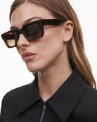 Model wearing 05 Core Brown Sunglasses, showcasing their stylish frame and lens design.
