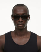 A model wearing 05 Core Brown Sunglasses, showcasing style and protection with durable materials.