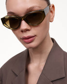 Close-up of a model wearing 06 Core Green Sunglasses with a chic outfit, showcasing stylish eyewear.