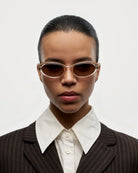 09 Core Ecru Sunglasses worn by a model in a stylish suit against a plain background.