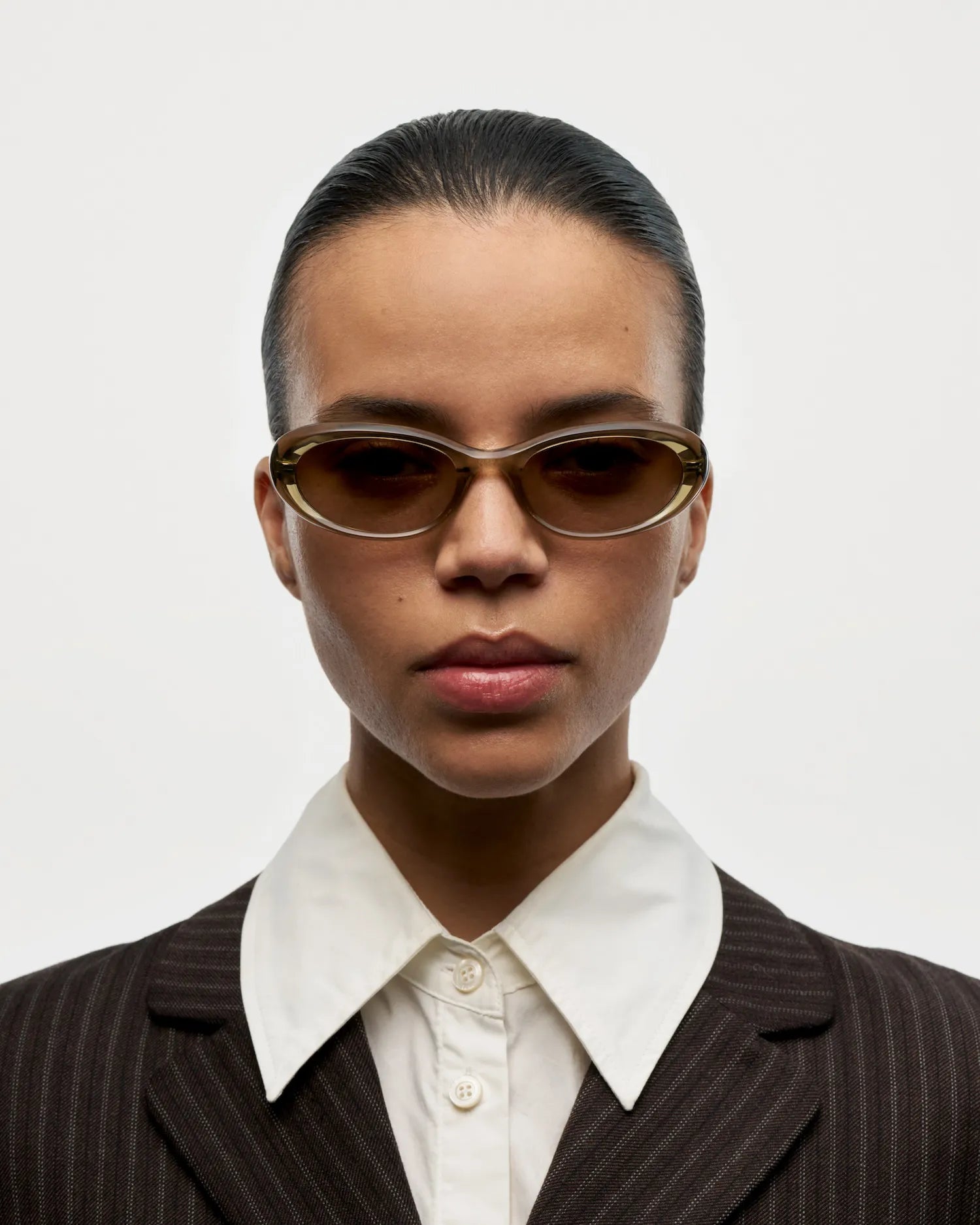 09 Core Green Sunglasses worn by a model in a stylish suit with a classic collar against a neutral background.