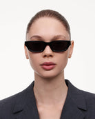 10 Core Black Sunglasses worn by a model with sleek hairstyle and stylish outfit against a clean background.
