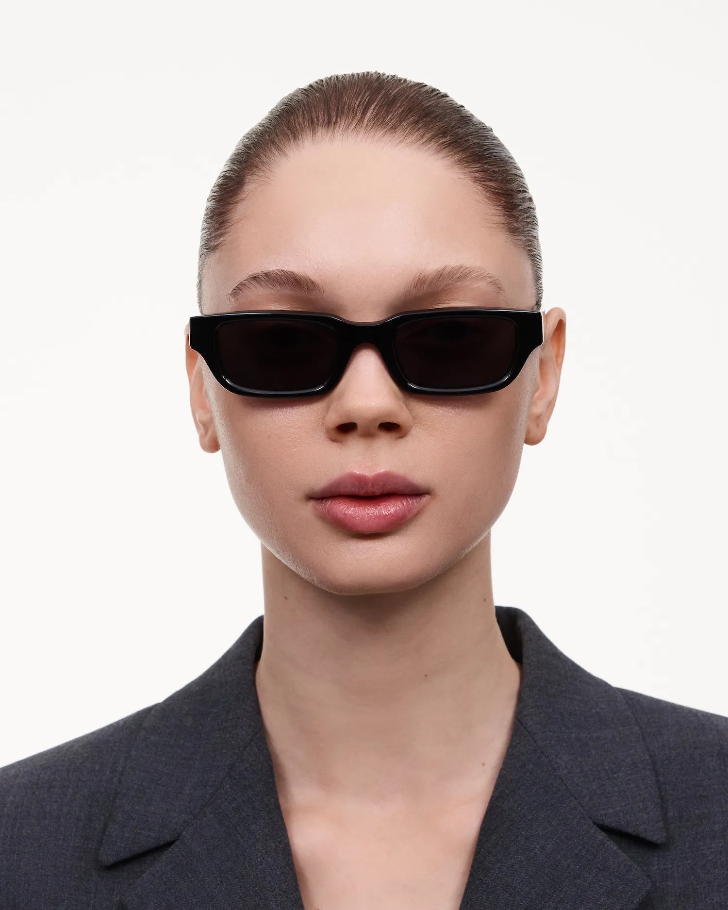 10 Core Black Sunglasses worn by a model with sleek hairstyle and stylish outfit against a clean background.