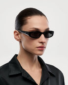 Note Black Sunglasses on a model, showcasing sleek design and UVA + UVB protection. Limited edition eyewear.